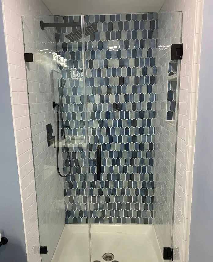Walk-in shower with blue mosaic tile accent wall and matte black fixtures