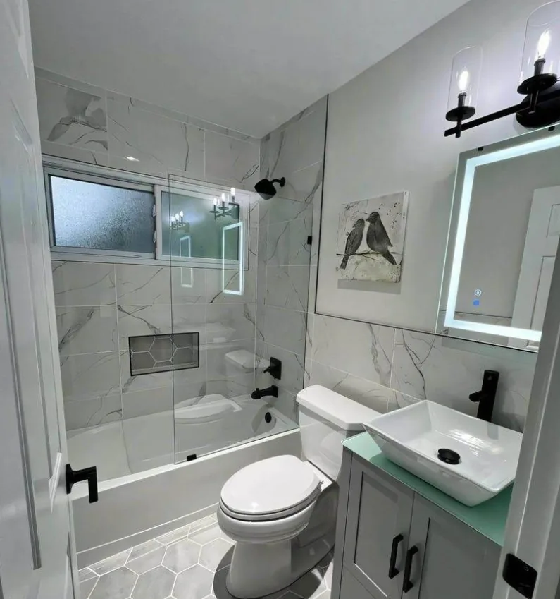 Complete bathroom remodel with marble tile and frameless glass