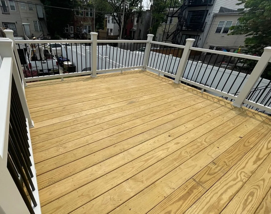New pressure treated deck with black metal railings and city backdrop