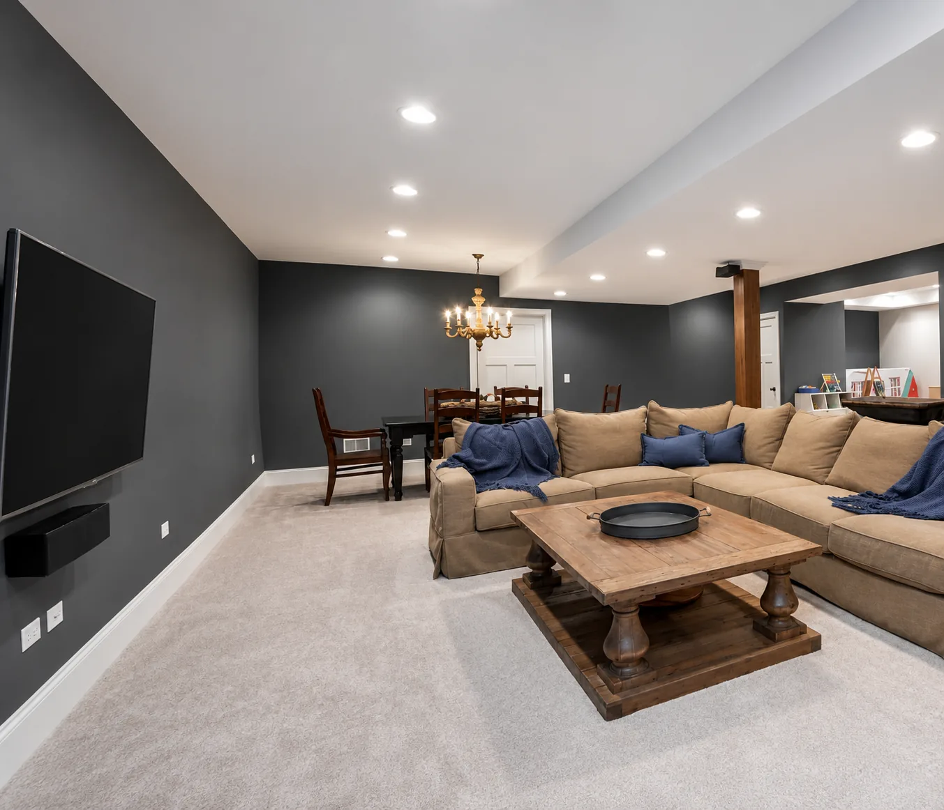 Remodeled living room with charcoal accent wall, recessed lighting, and open dining area by DMV Home Improvement LLC in Washington, D.C.