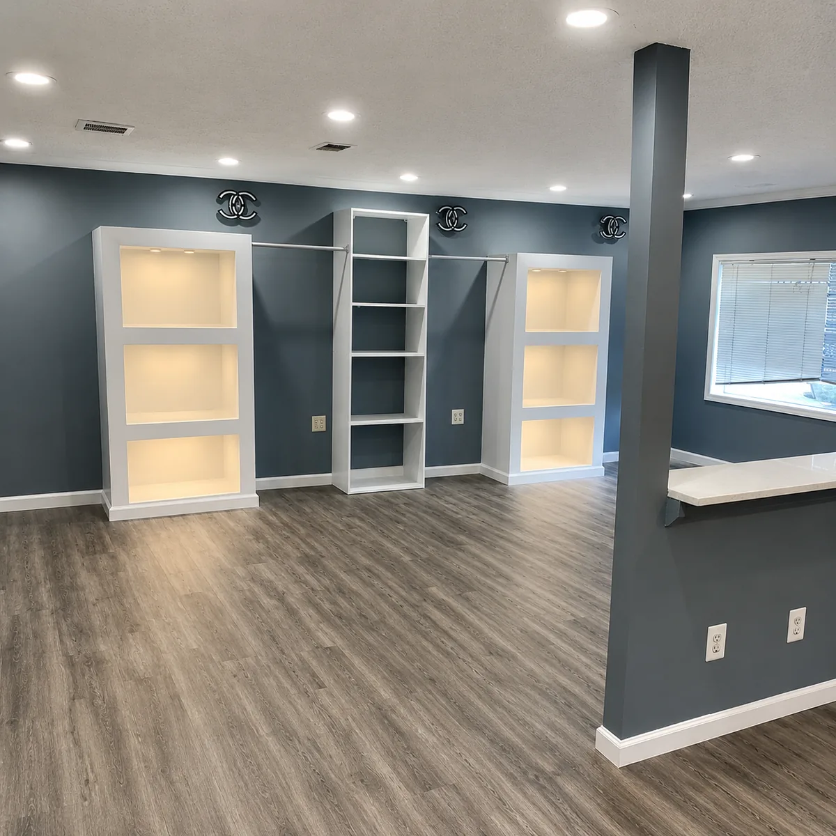 Living room remodel with navy accent wall and lit built-in shelving