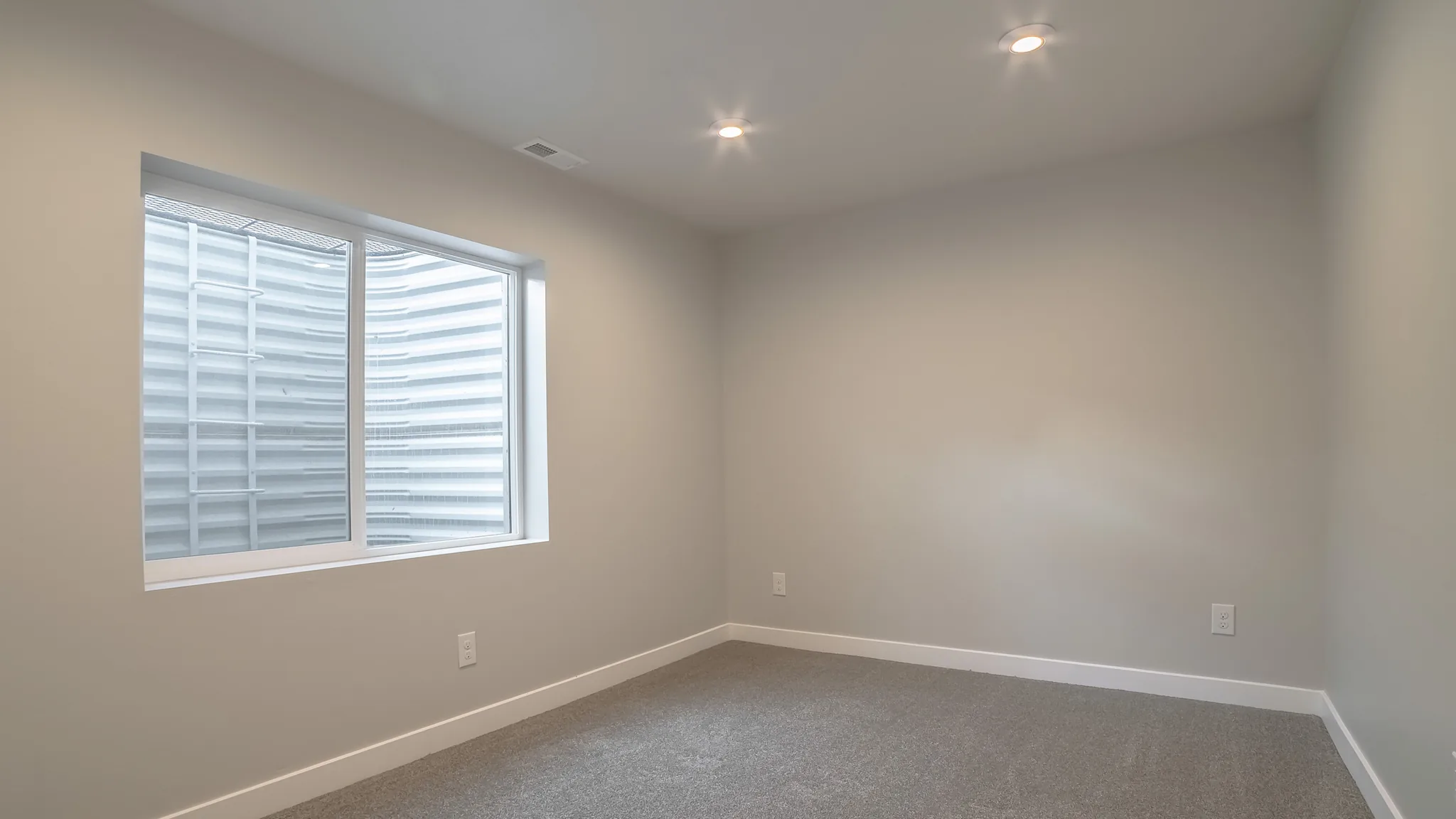 Clean finished basement room with egress window