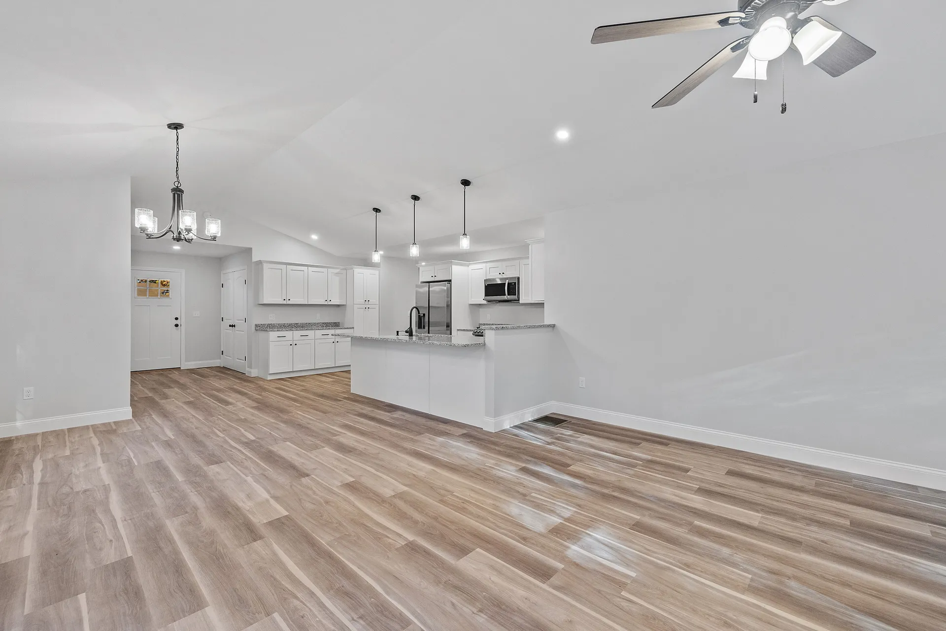 Open kitchen and living area with the dividing wall removed and wood-look flooring throughout