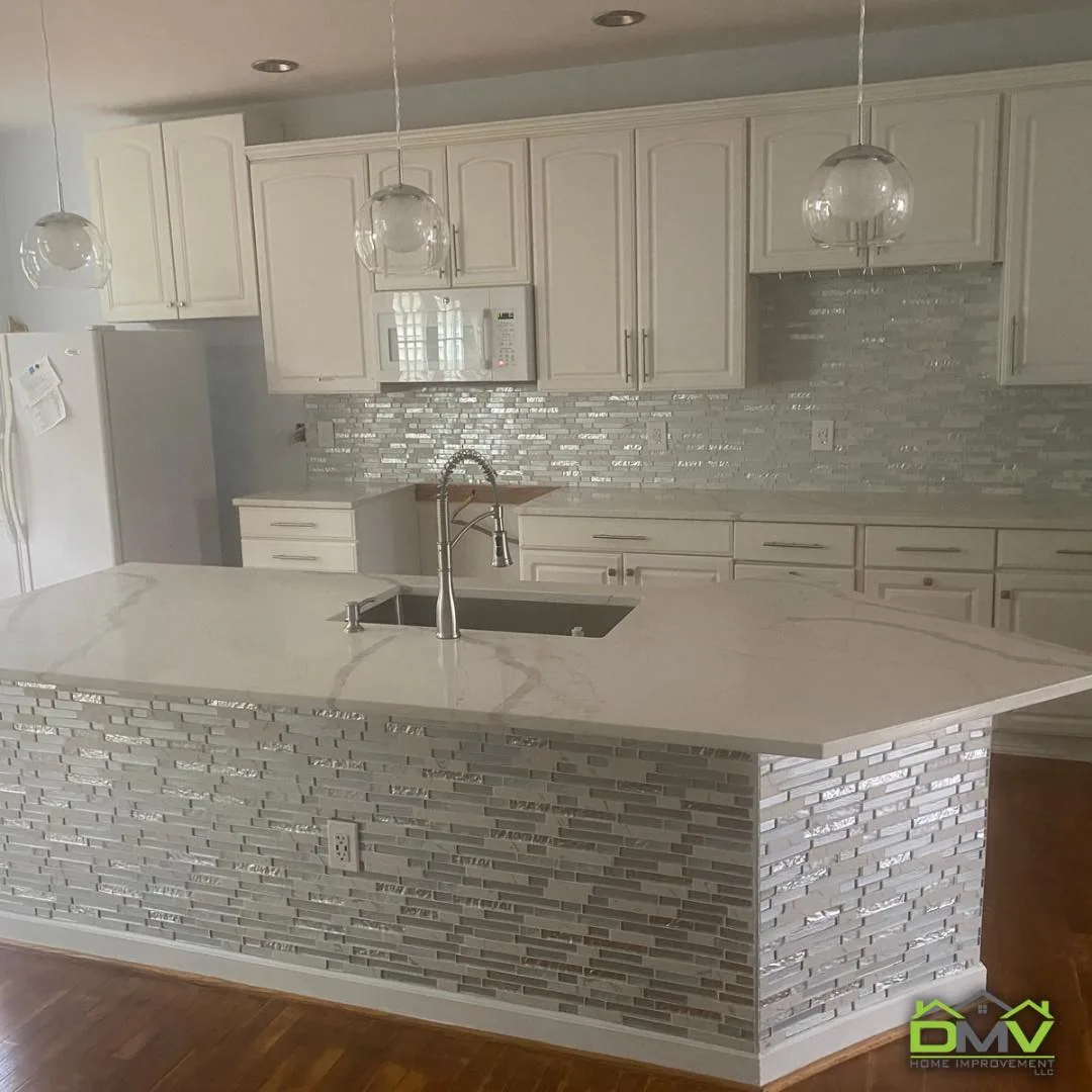 White shaker kitchen remodel with quartz island and glass mosaic backsplash