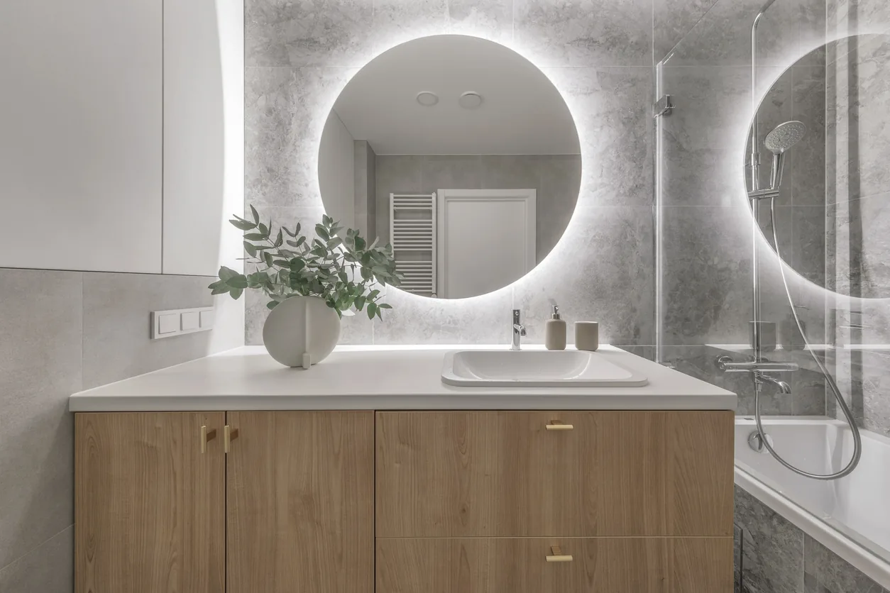 Modern vanity with backlit mirror and stone tile
