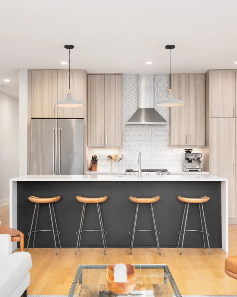 Contemporary kitchen with dark island and light wood cabinets
