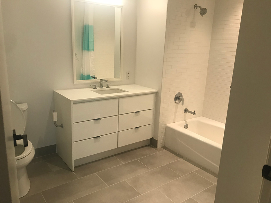 Slick custom bathroom renovation, custom vanity, tiled shower walls and large floor tiles.